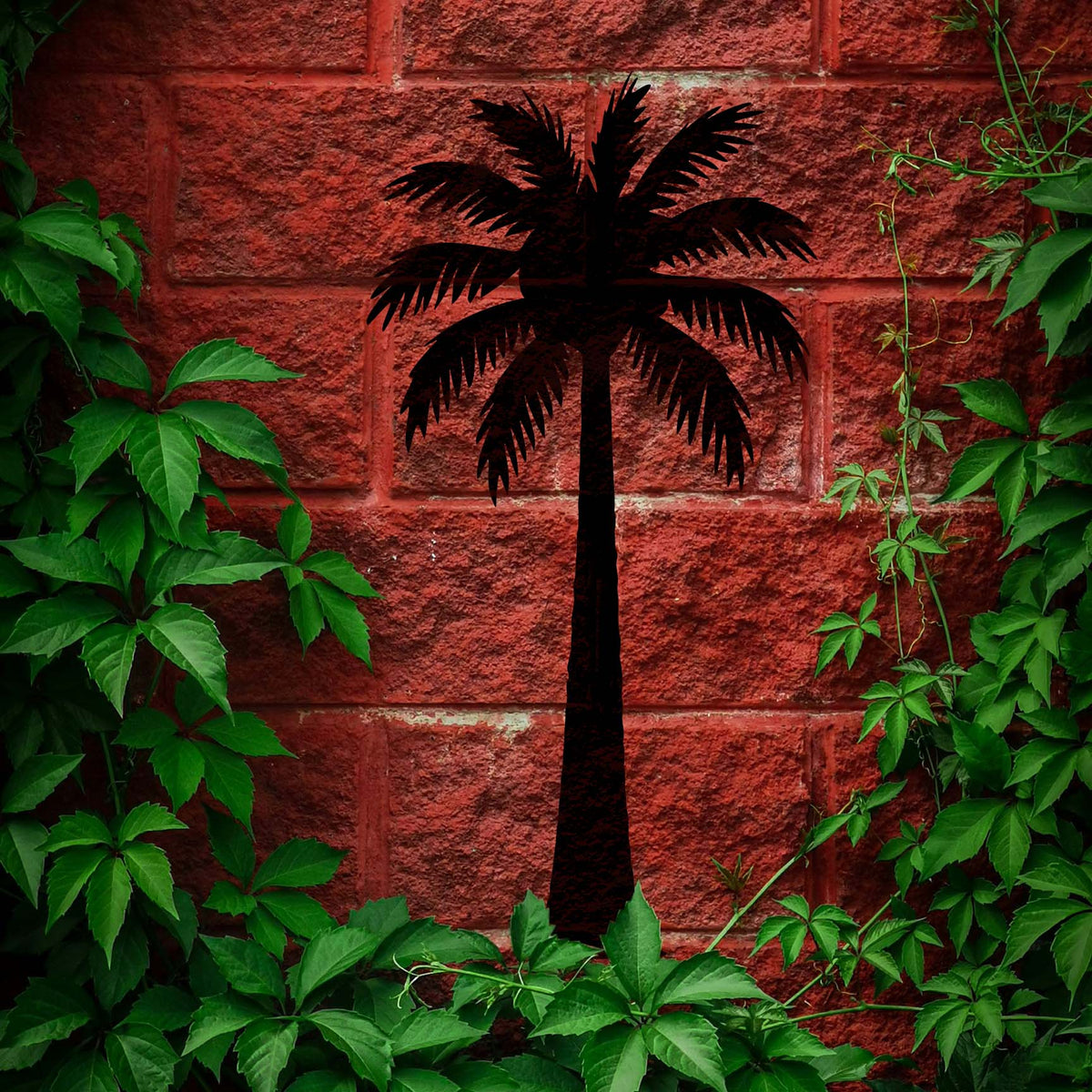 Tropical palm tree stencil standing boldly against a vine-covered red brick wall