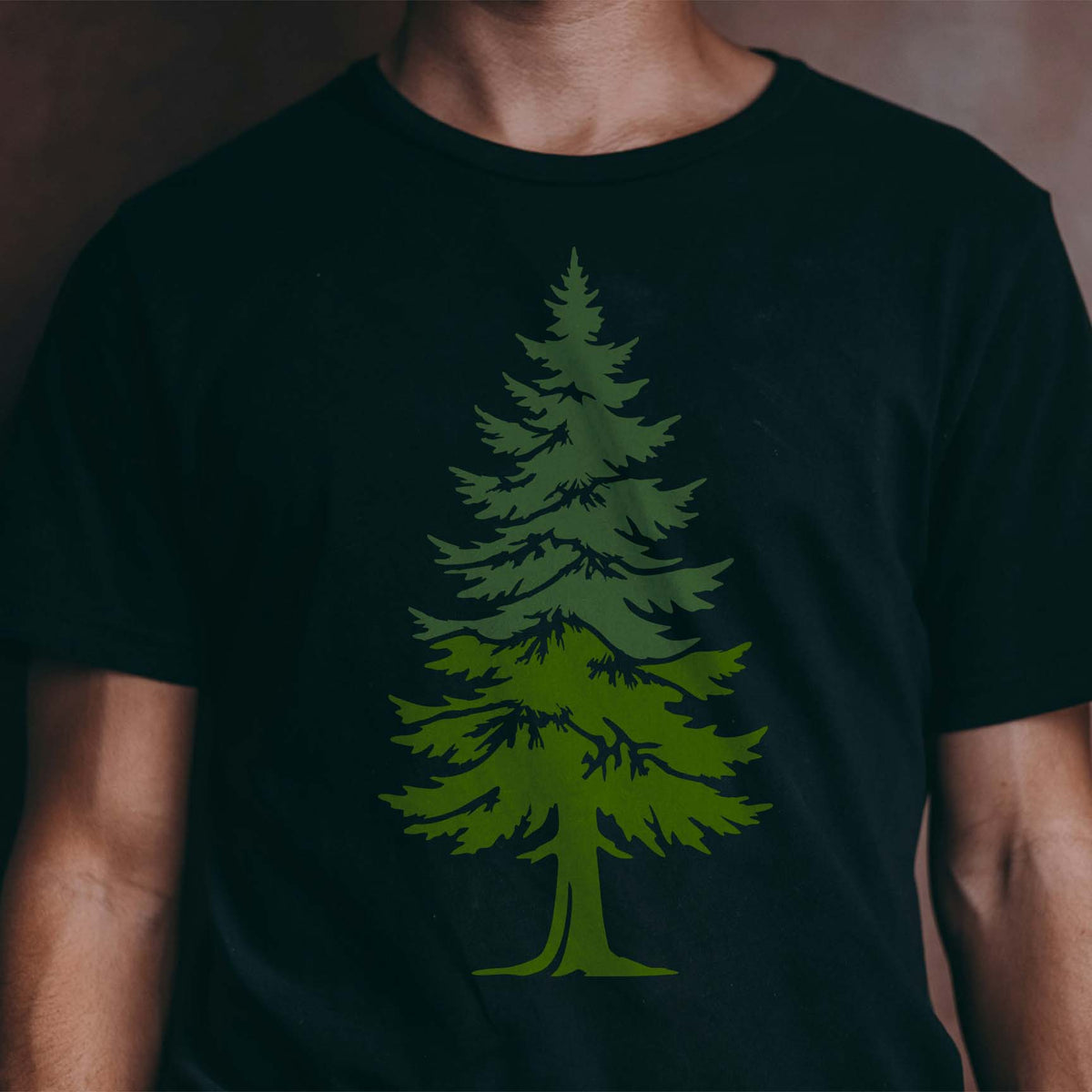 Forest green pine tree stencil rising across the front of a black shirt