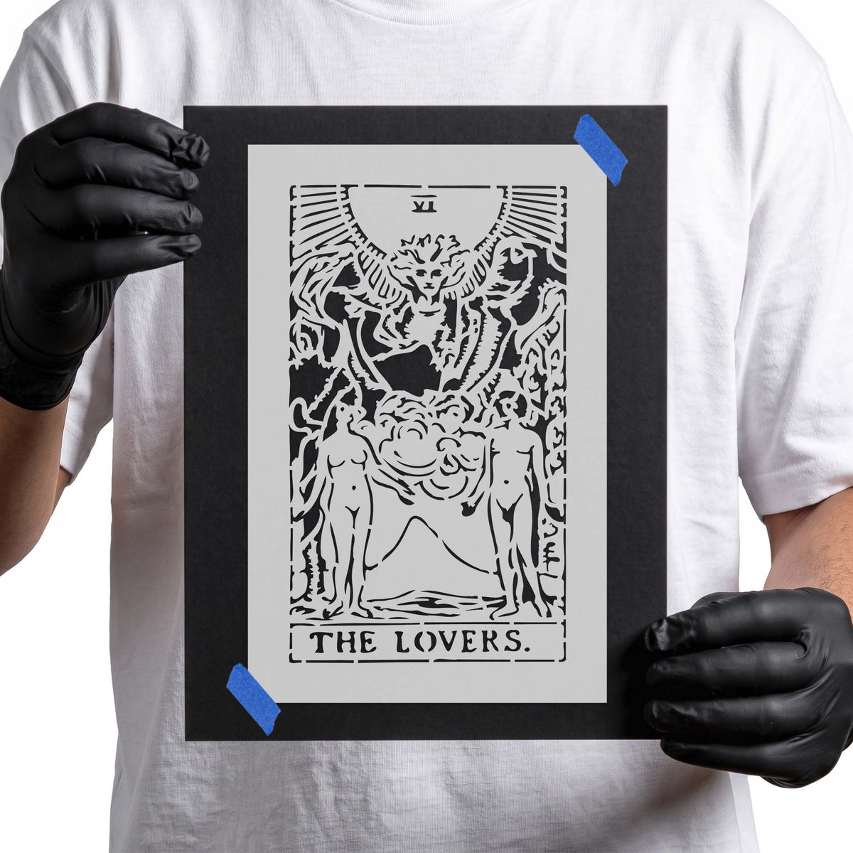 Tarot stencil with two figures beneath a detailed winged figure