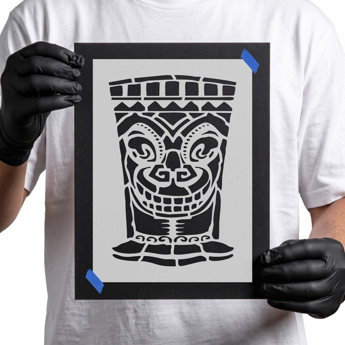 Smiling tiki face stencil with bold eyes, toothy grin, and geometric details