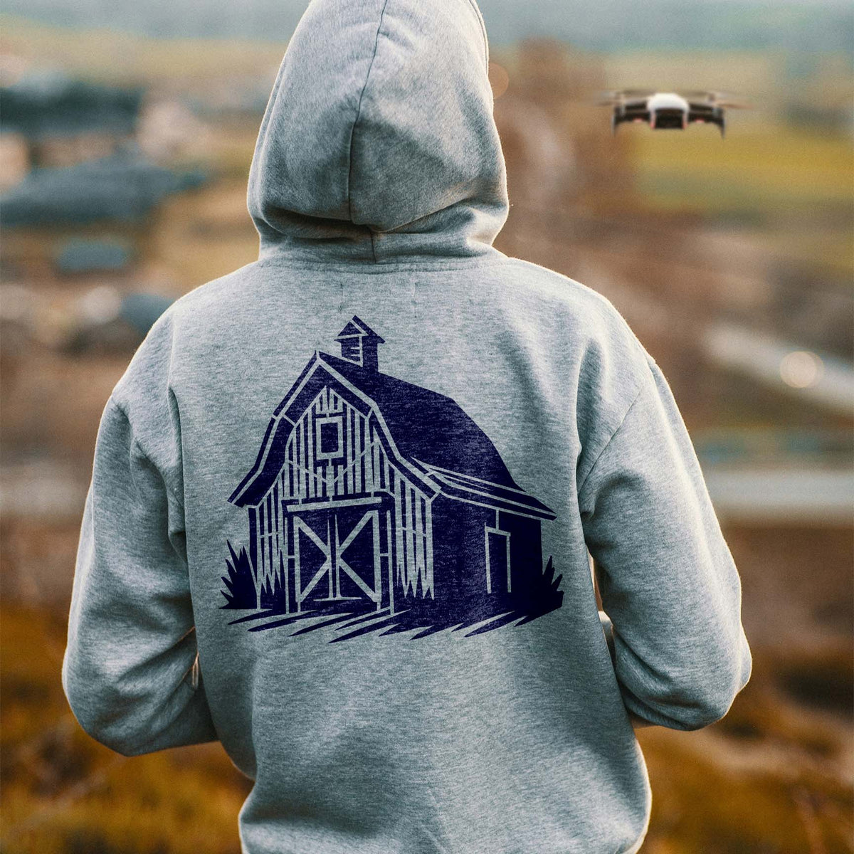 Traditional Wooden Barn Stencil printed in dark blue on the back of a gray hoodie.