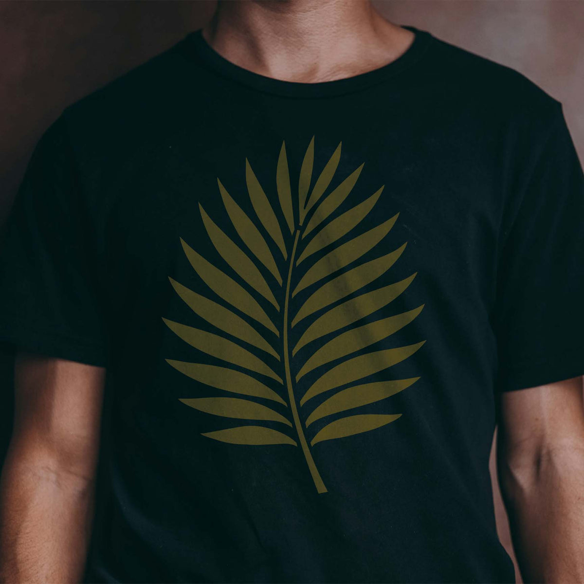 Sleek tropical palm frond stencil centered boldly on a dark shirt