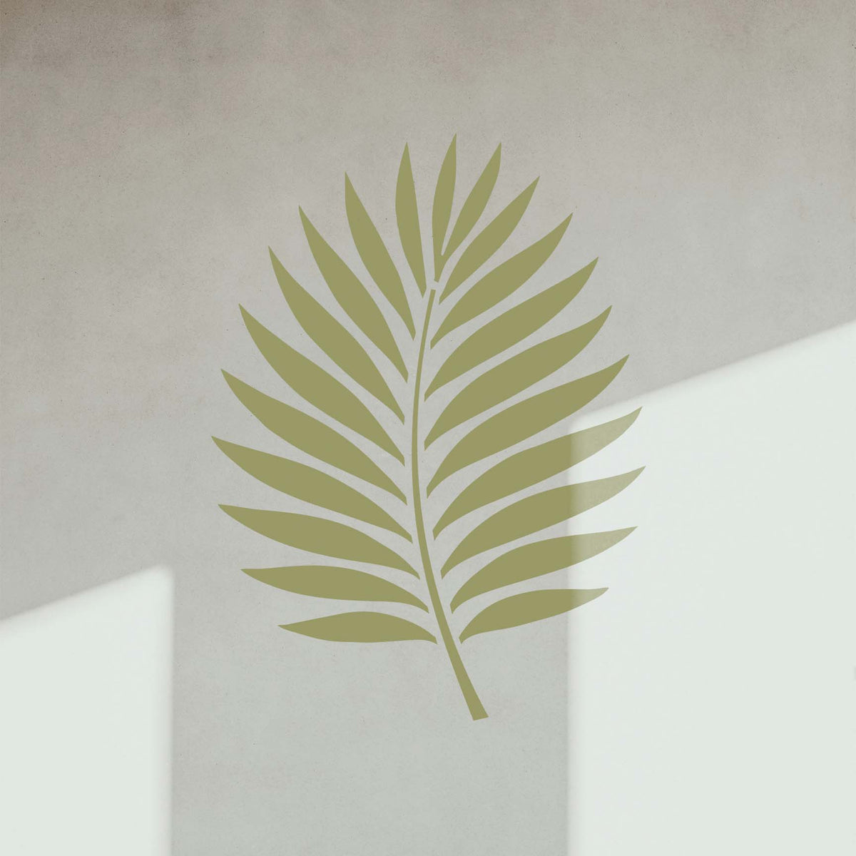 Soft olive palm frond stencil accented by natural shadows on a wall