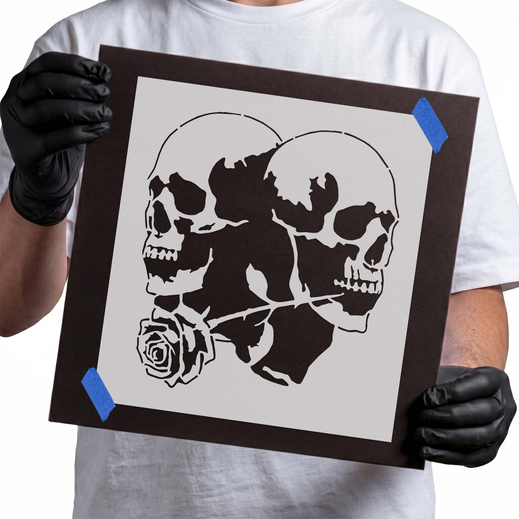 Two opposing human skulls connected by a single rose in a detailed gothic stencil design