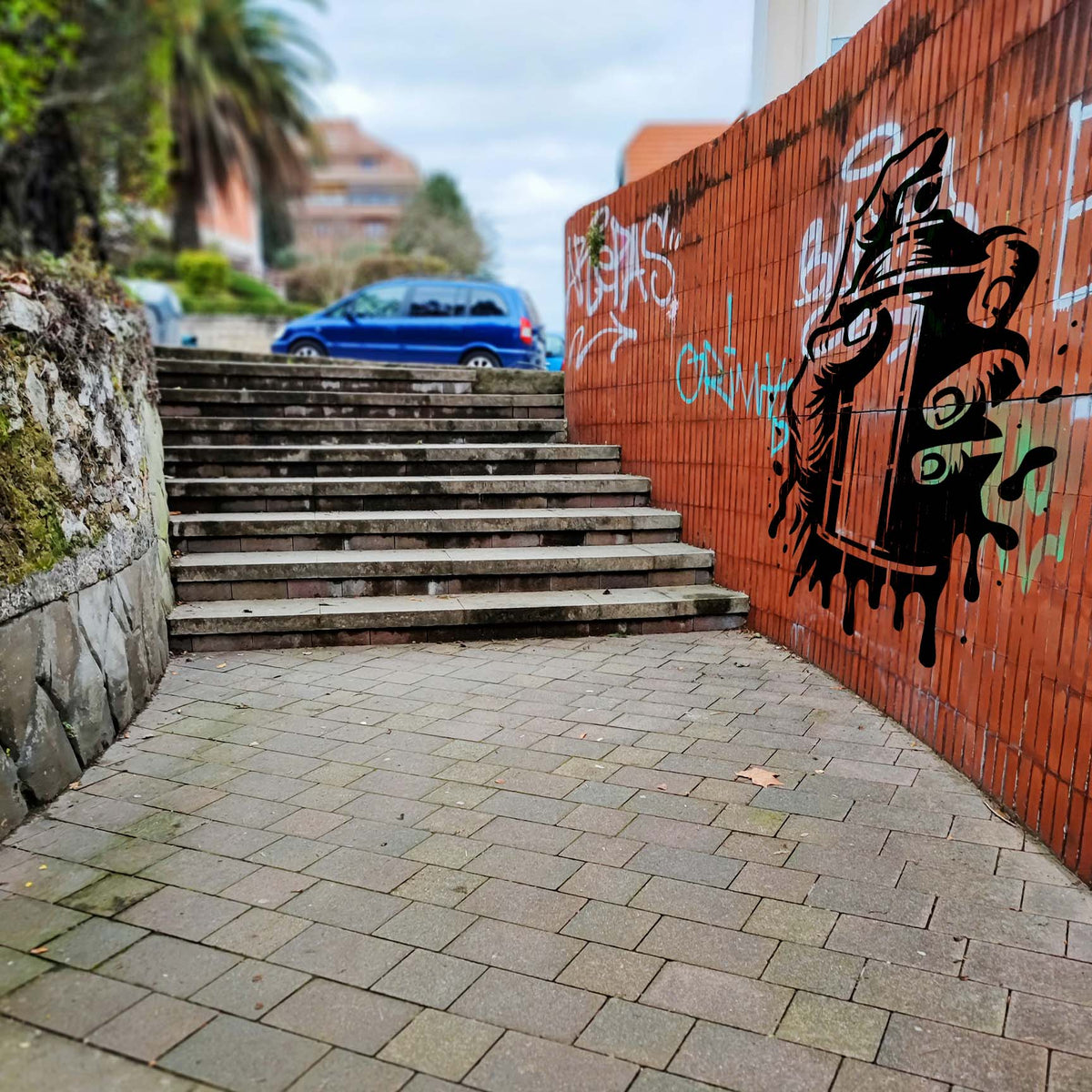 Beside outdoor steps, the Urban Spray Paint Can Stencil stands out in black on an orange wall.