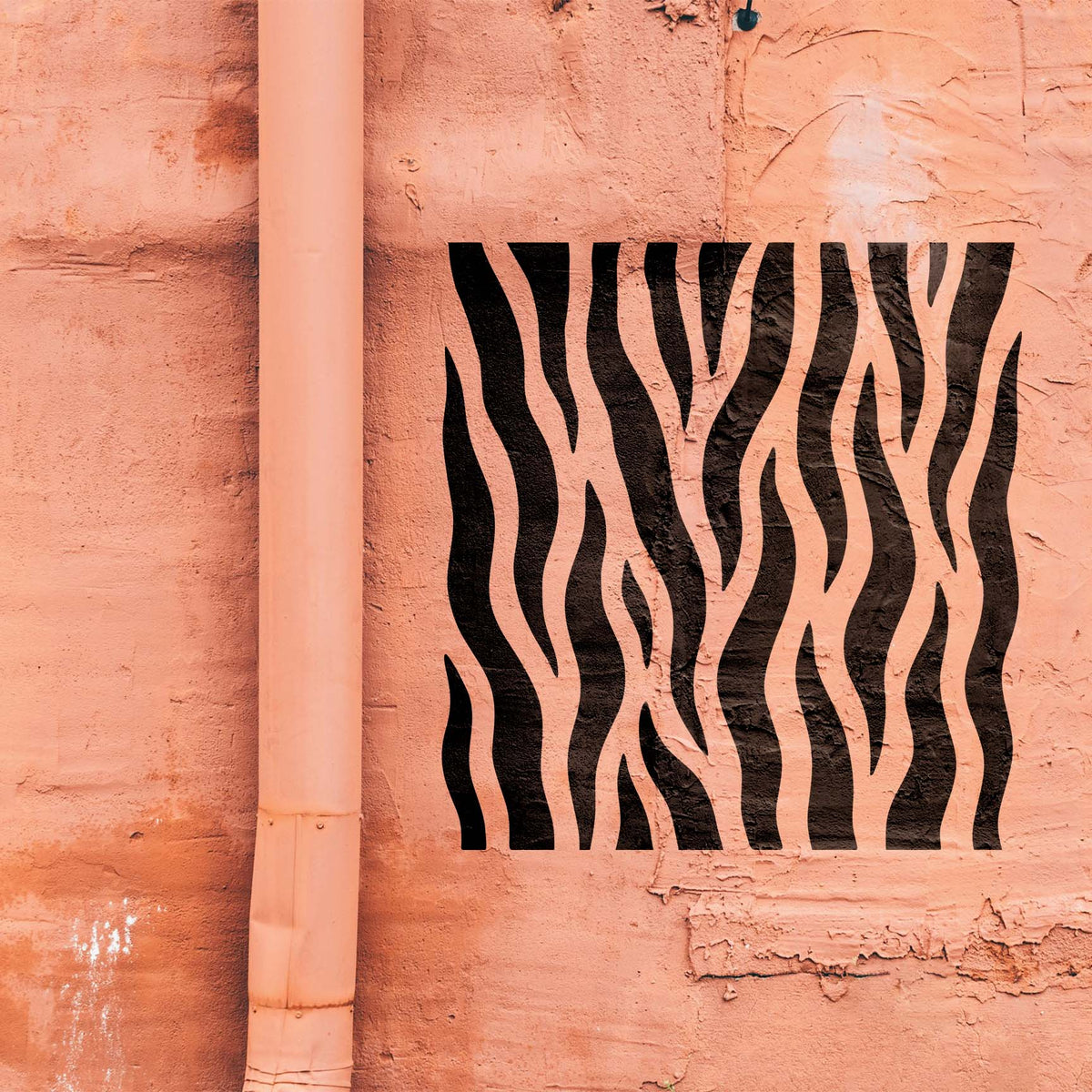 Across a textured salmon wall, the Vertical Tiger Stripe Pattern Stencil appears in bold black