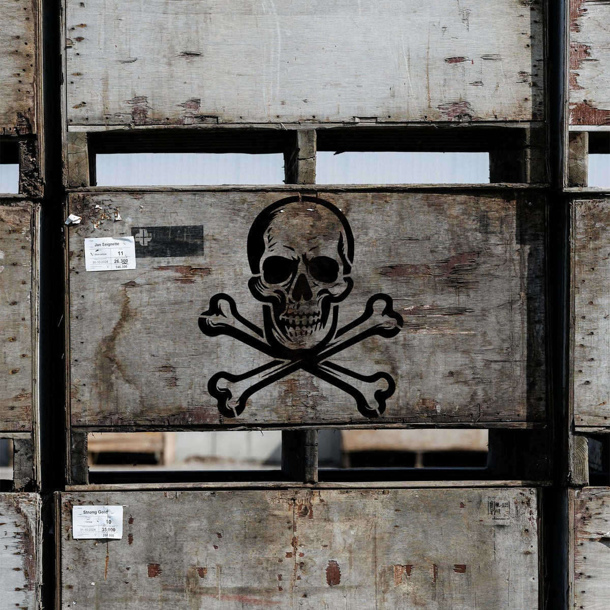 Weathered wooden crates display the Vintage Skull and Crossbones Stencil in bold black paint