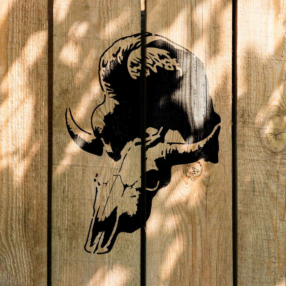 Sunlit wood planks display the Vulture Skull Silhouette Stencil with its striking horned skull design
