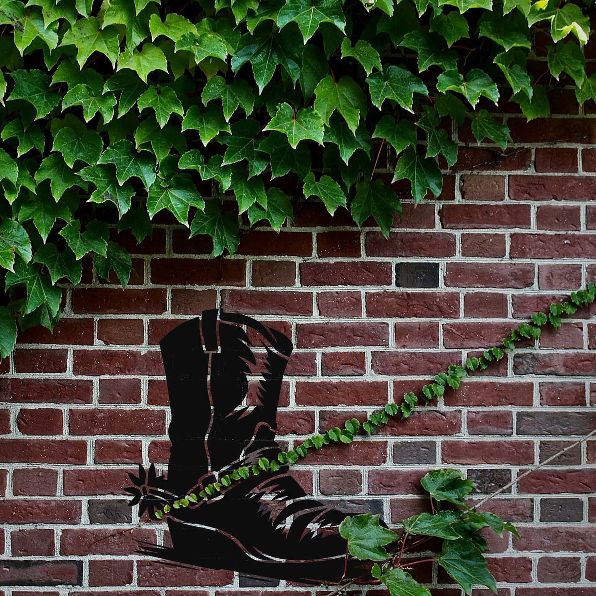 Western Cowboy Boot Stencil appears in black on a red brick wall with green ivy above.