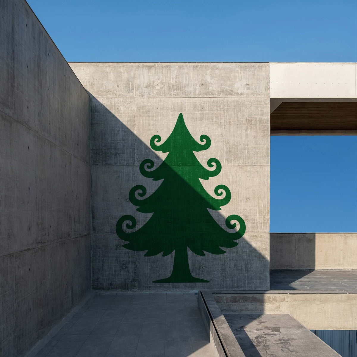 Whimsical Christmas Tree Stencil painted in green on a modern concrete wall with bold shadows.