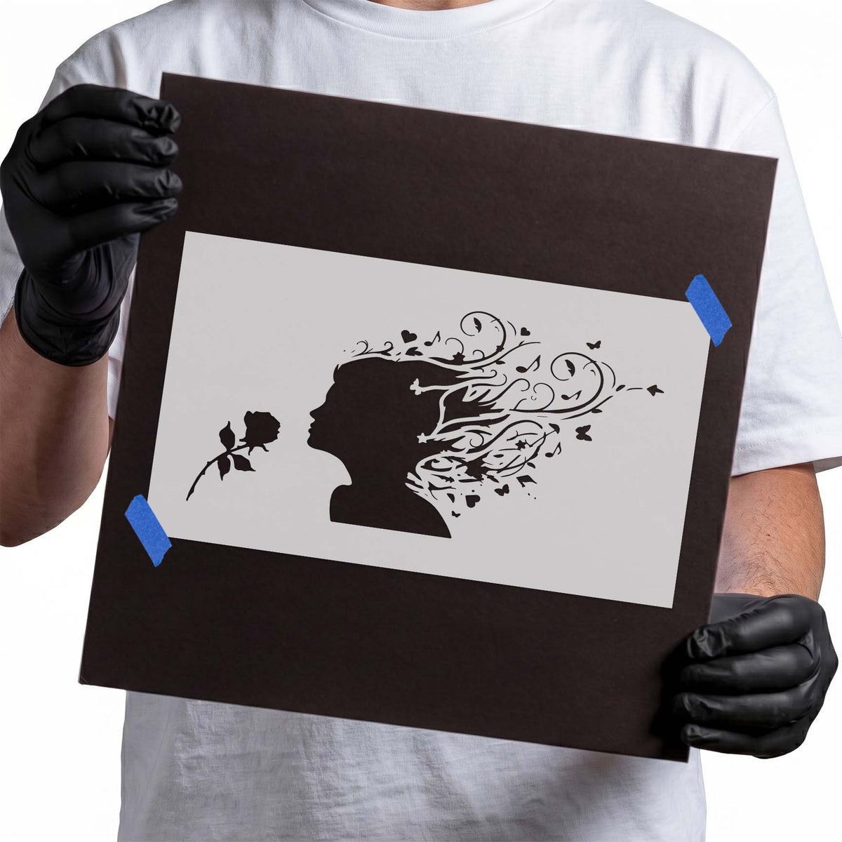 Woman silhouette stencil facing a rose with flowing floral hair details