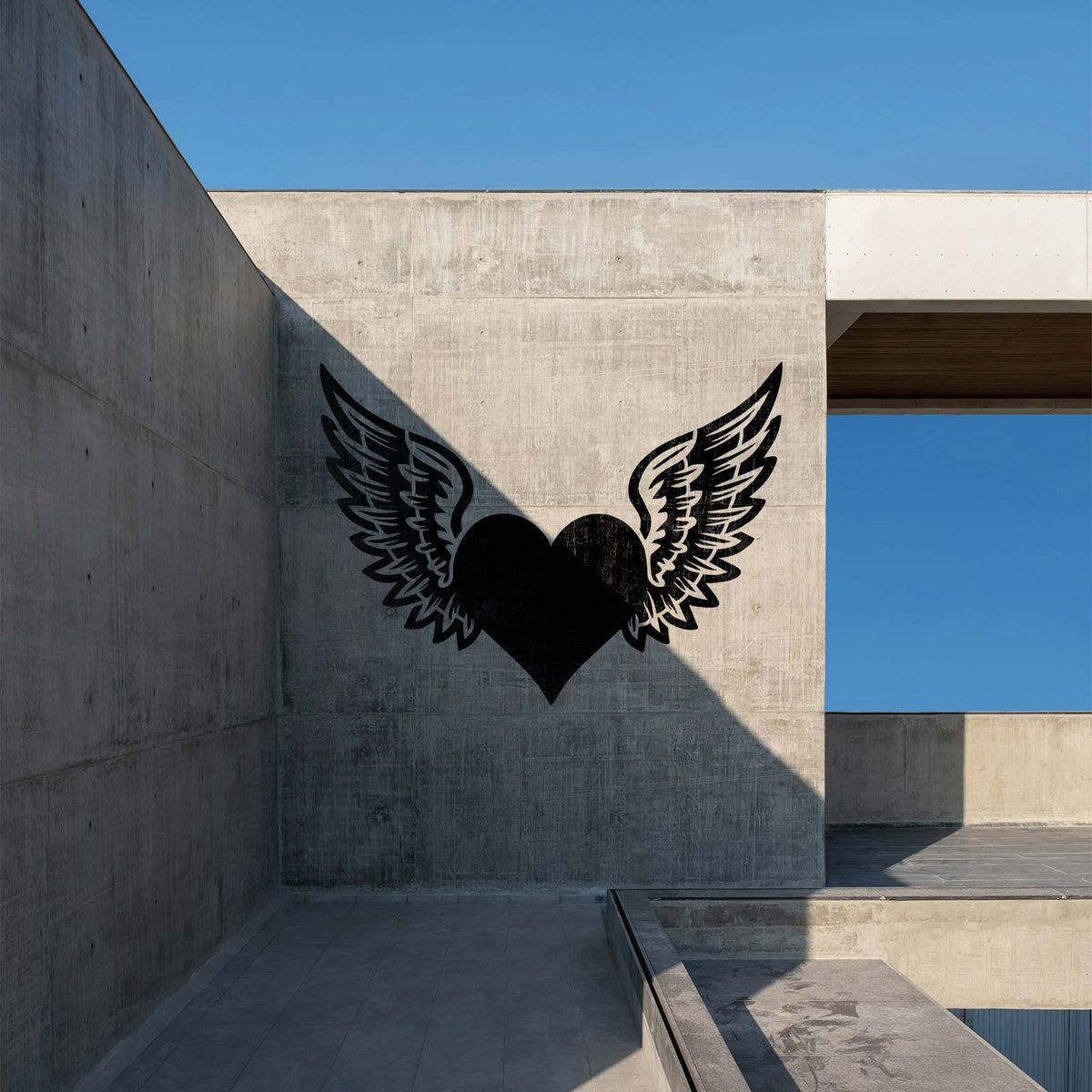 Winged Heart Love Symbol Stencil makes a bold black heart and feathered wings on a concrete wall