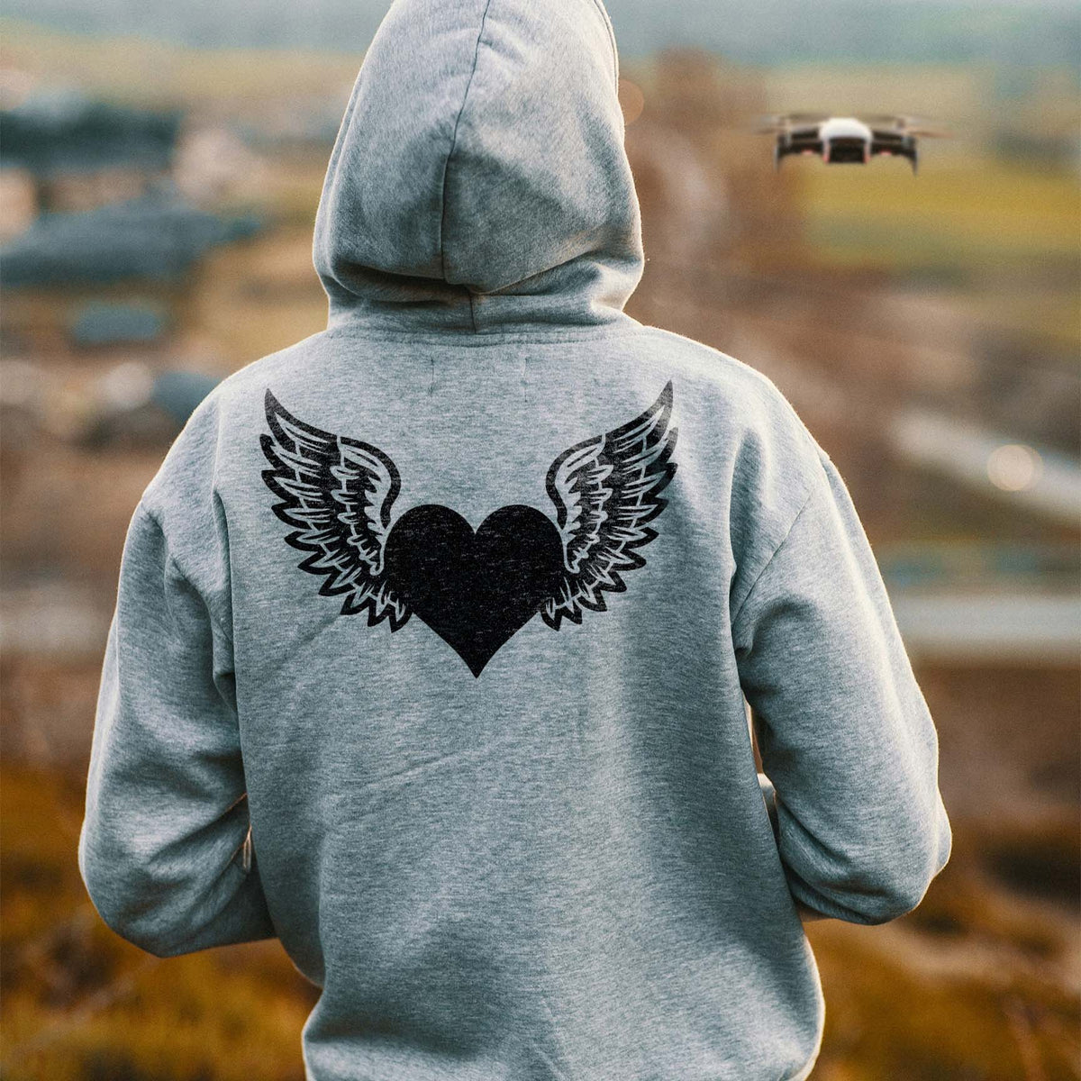 A gray hoodie features the Winged Heart Love Symbol Stencil with a black heart and detailed wings