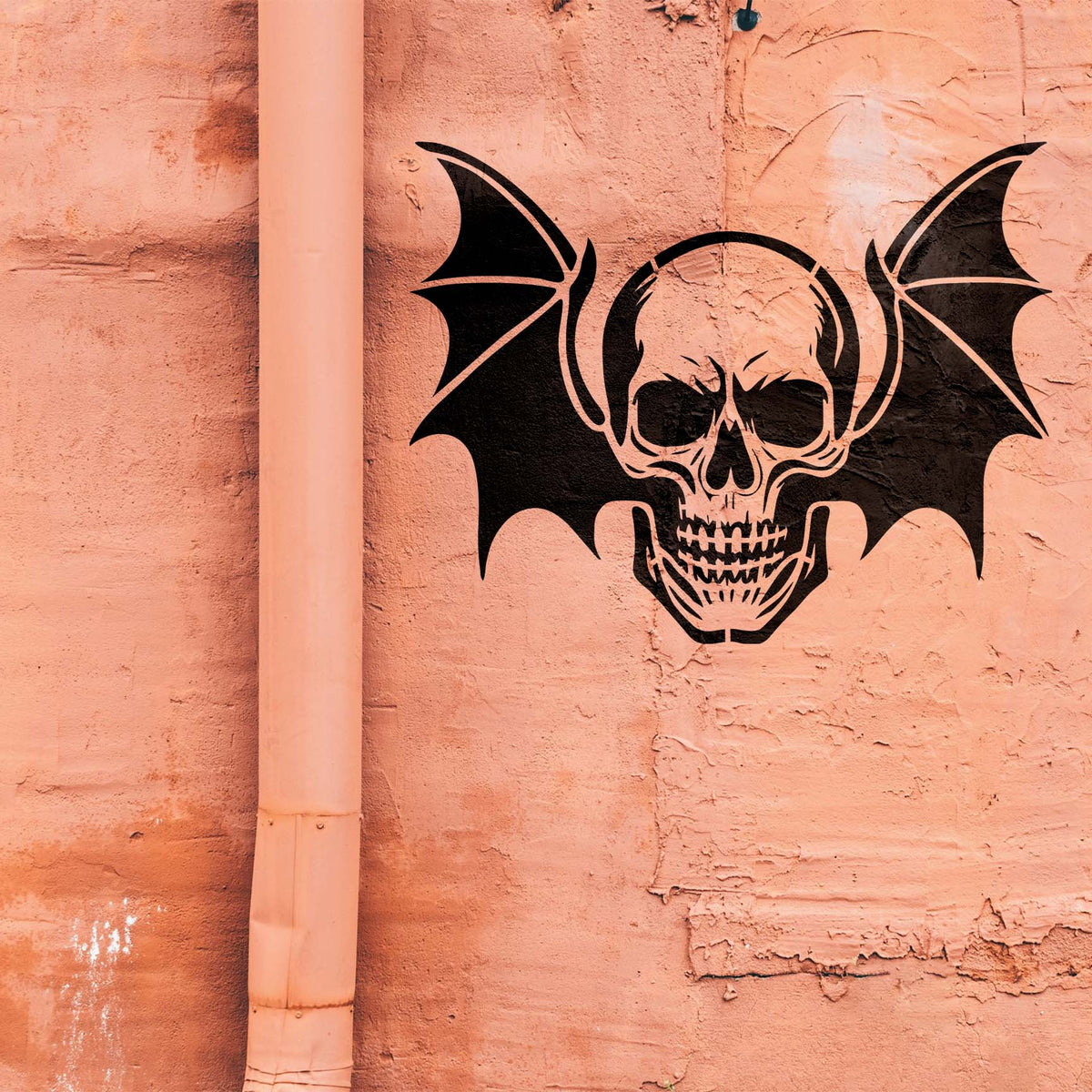 A peach textured wall features the Winged Skull Gothic Stencil with dramatic bat wings
