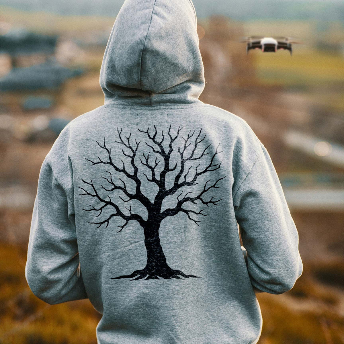 Winter tree stencil with bare branching silhouette printed on a gray hoodie
