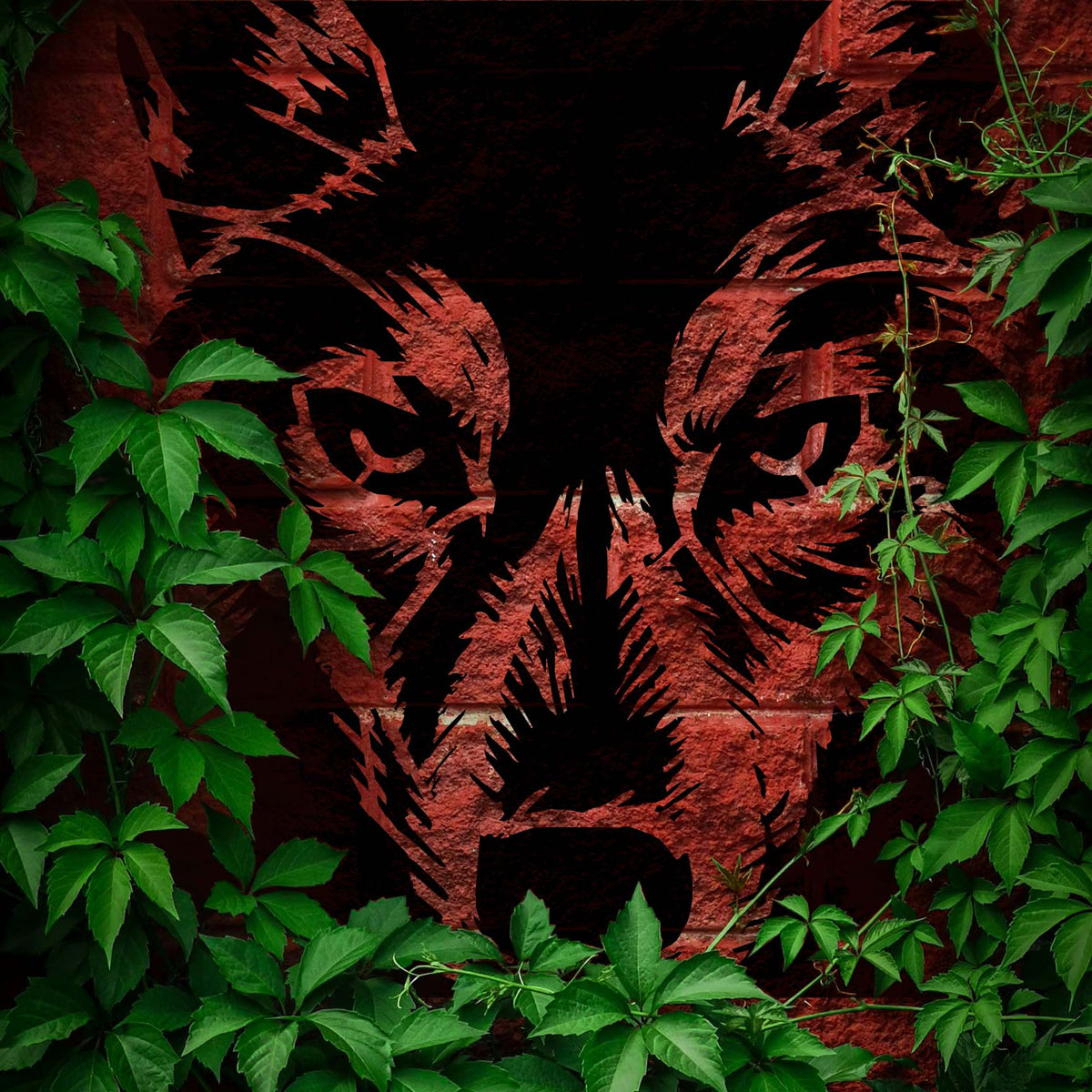 Framed by green ivy, the Wolf Eyes Close-Up Stencil reveals an intense black wolf face on rustic red brick.