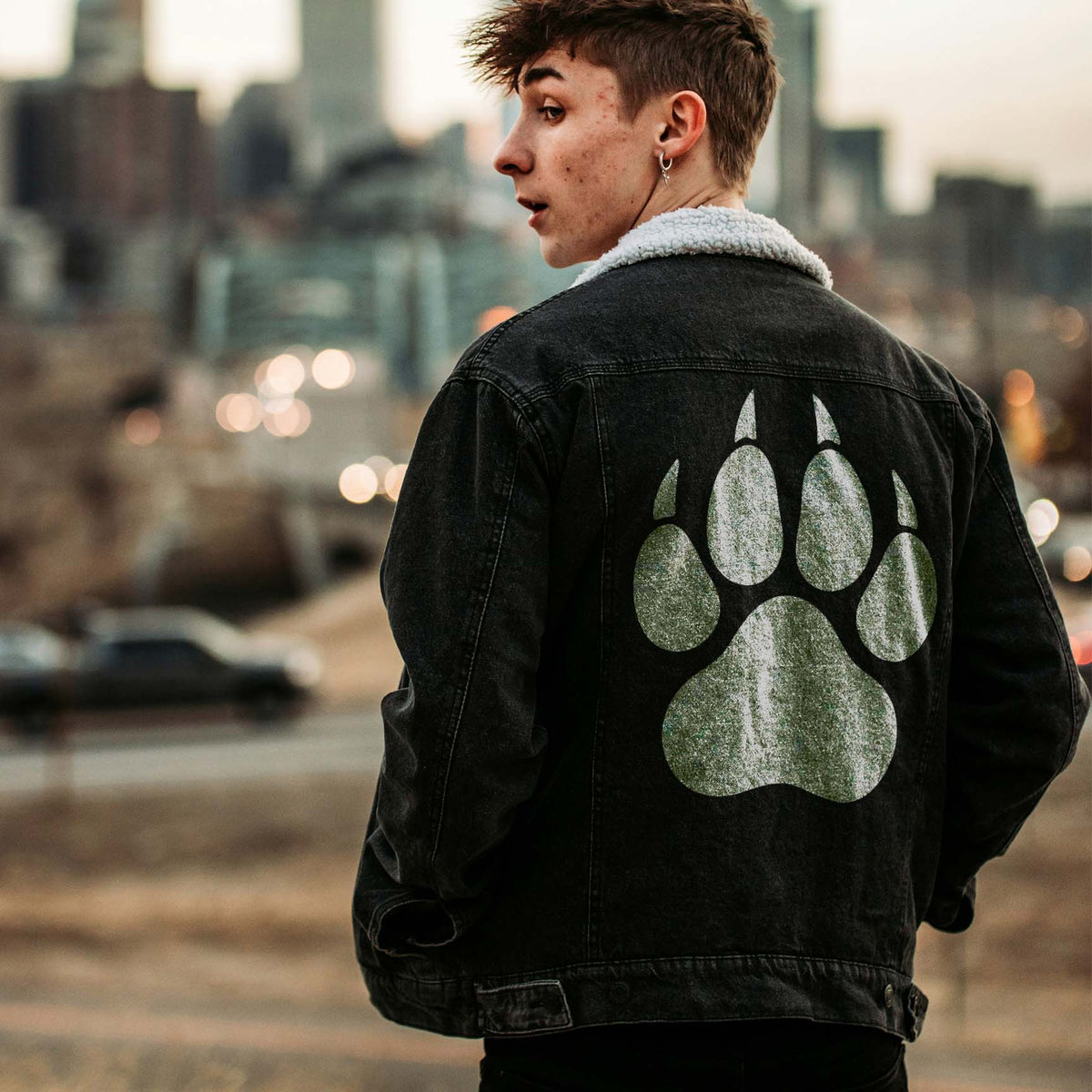 Worn on a black denim jacket, the Wolf Paw Print Stencil stands out in distressed white