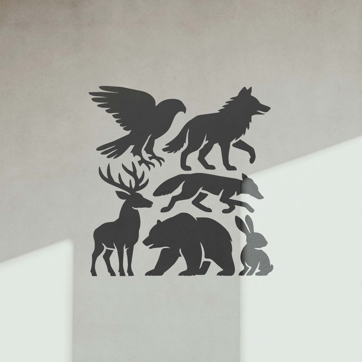 Six forest figures from the Woodland Animal Silhouette Stencil decorate a softly lit wall