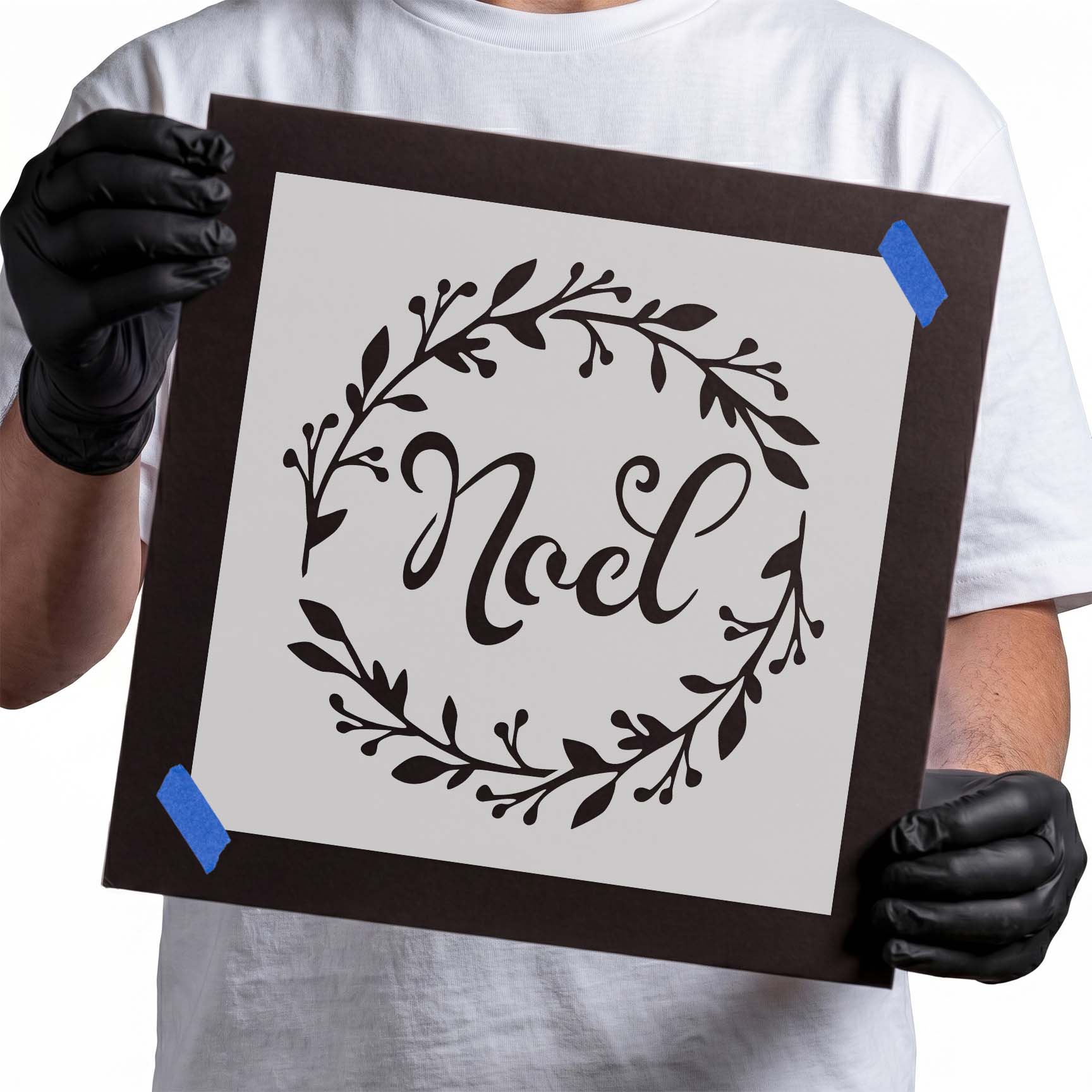 Noel script lettering surrounded by a circular leafy Christmas wreath