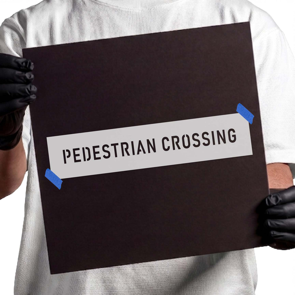 Pedestrian crossing stencil with narrow uppercase block lettering