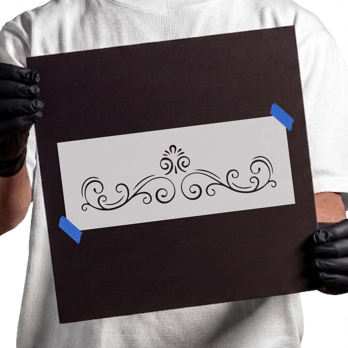 Ornamental stencil with symmetrical swirling scrolls and central flourish