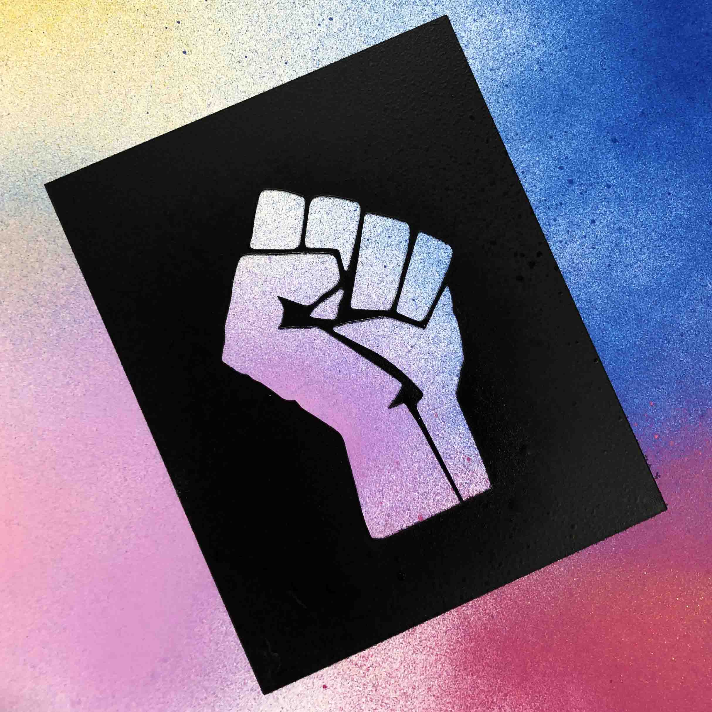 Raised fist stencil with colorful spray paint background.