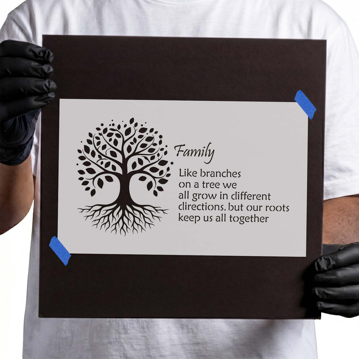 Family tree stencil with leafy branches, exposed roots, and family quote