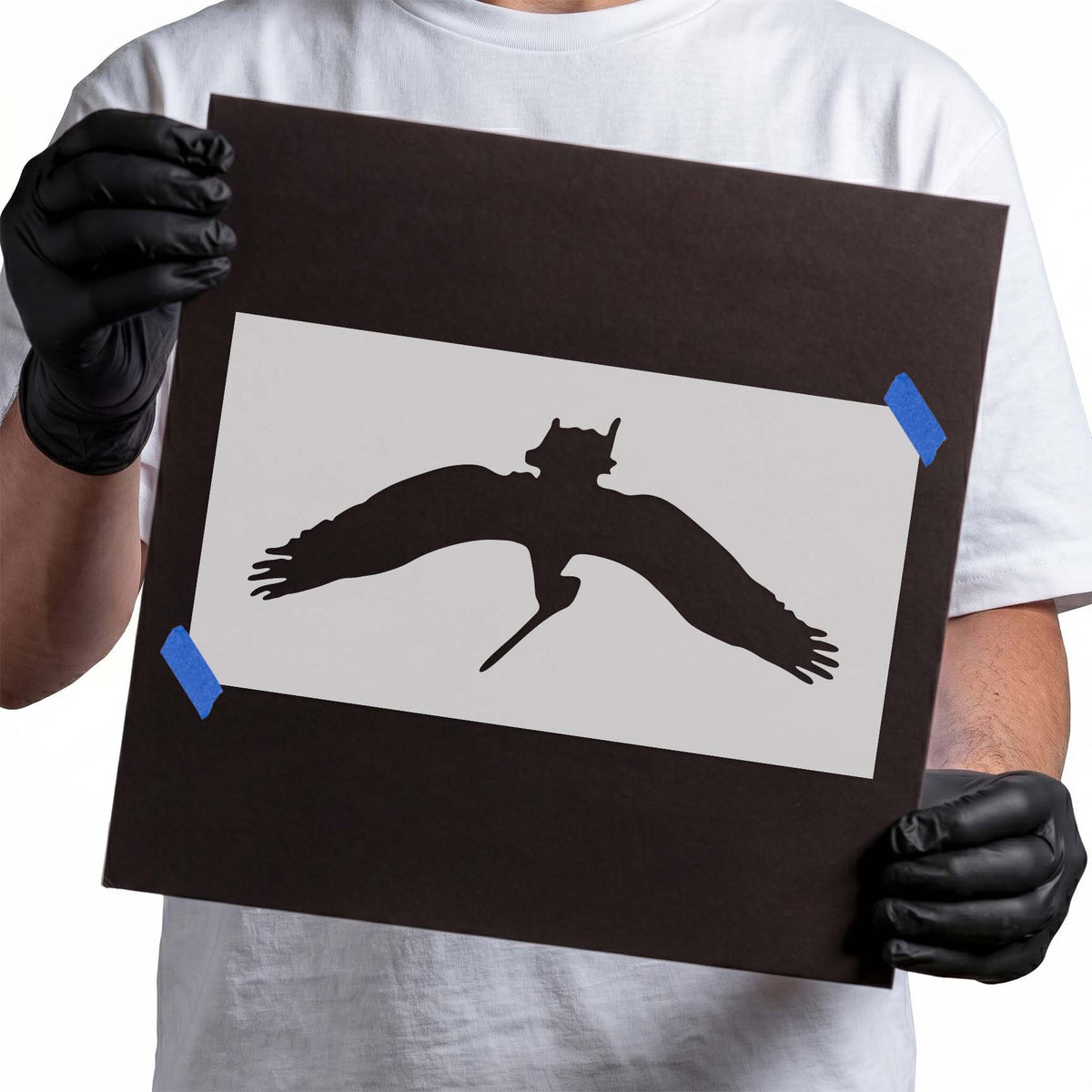 Flying pelican stencil featuring broad outstretched wings, spread feather tips, and an elongated bill