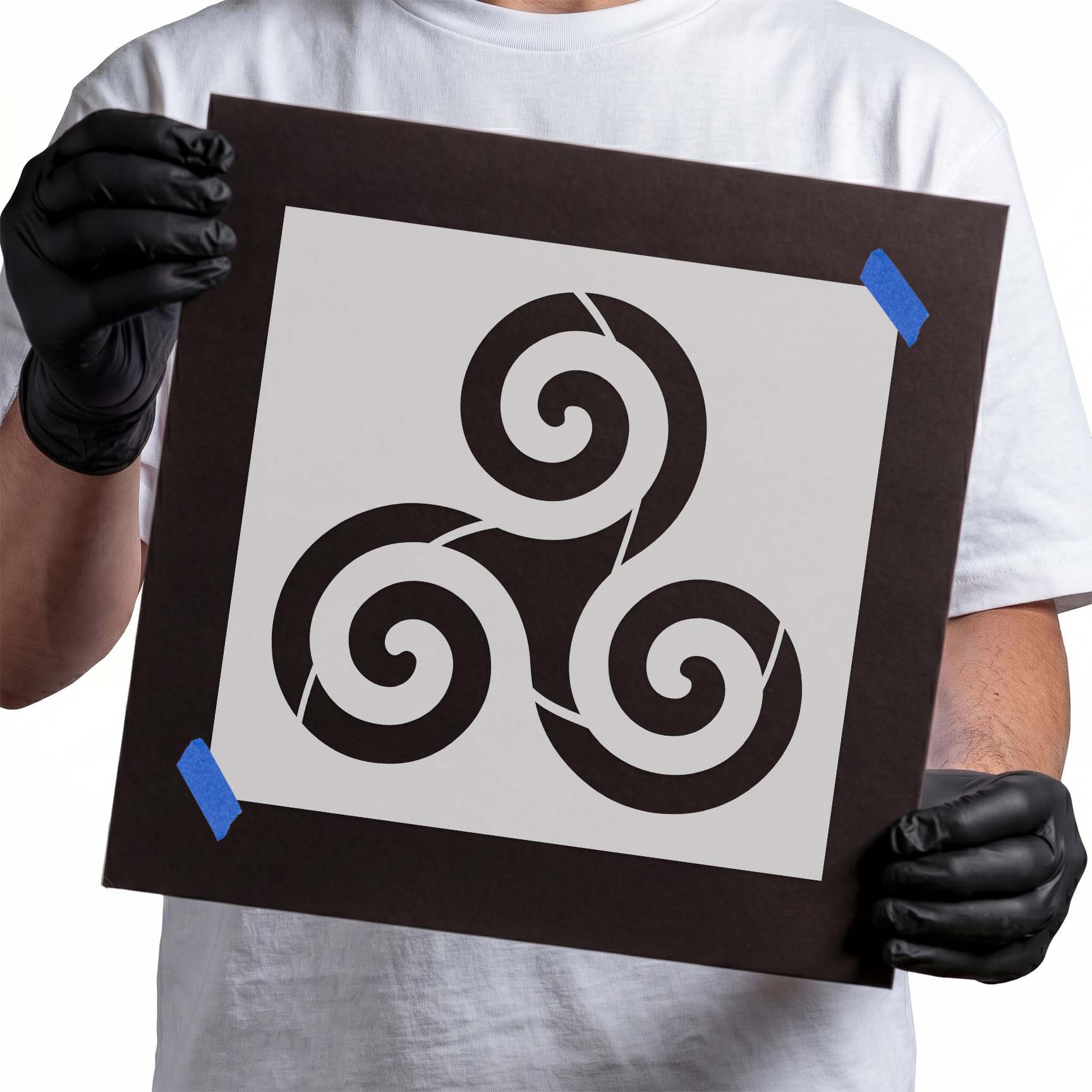 Person holding laser-cut Triskelion Stencil