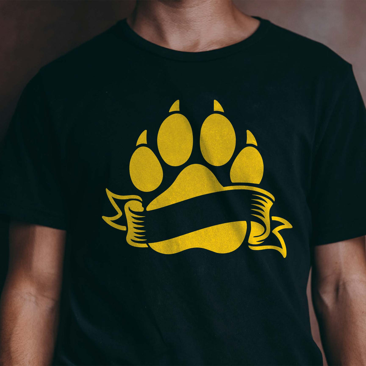 Blank Banner Paw Print Stencil shines in gold on a black T-shirt with a sweeping ribbon