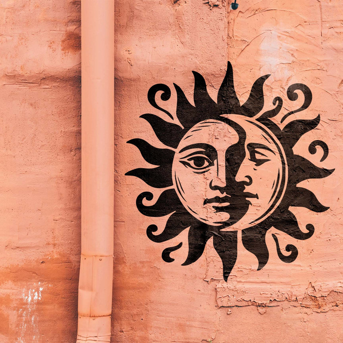 Celestial Sun and Moon Face Stencil brings a striking black dual-faced sun to a salmon stucco wall.