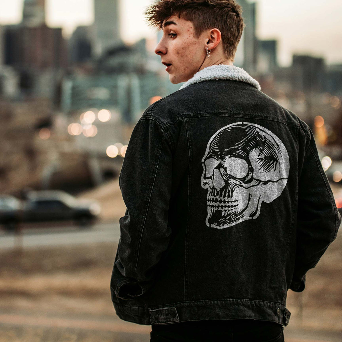 Bold Detailed Anatomical Skull Stencil decorates the back of a black denim jacket