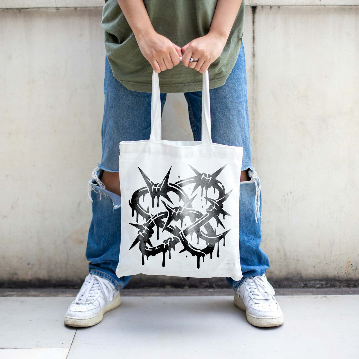 Printed on a white tote bag, the Graffiti Barbed Wire Stencil shows edgy dripping barbed wire art.