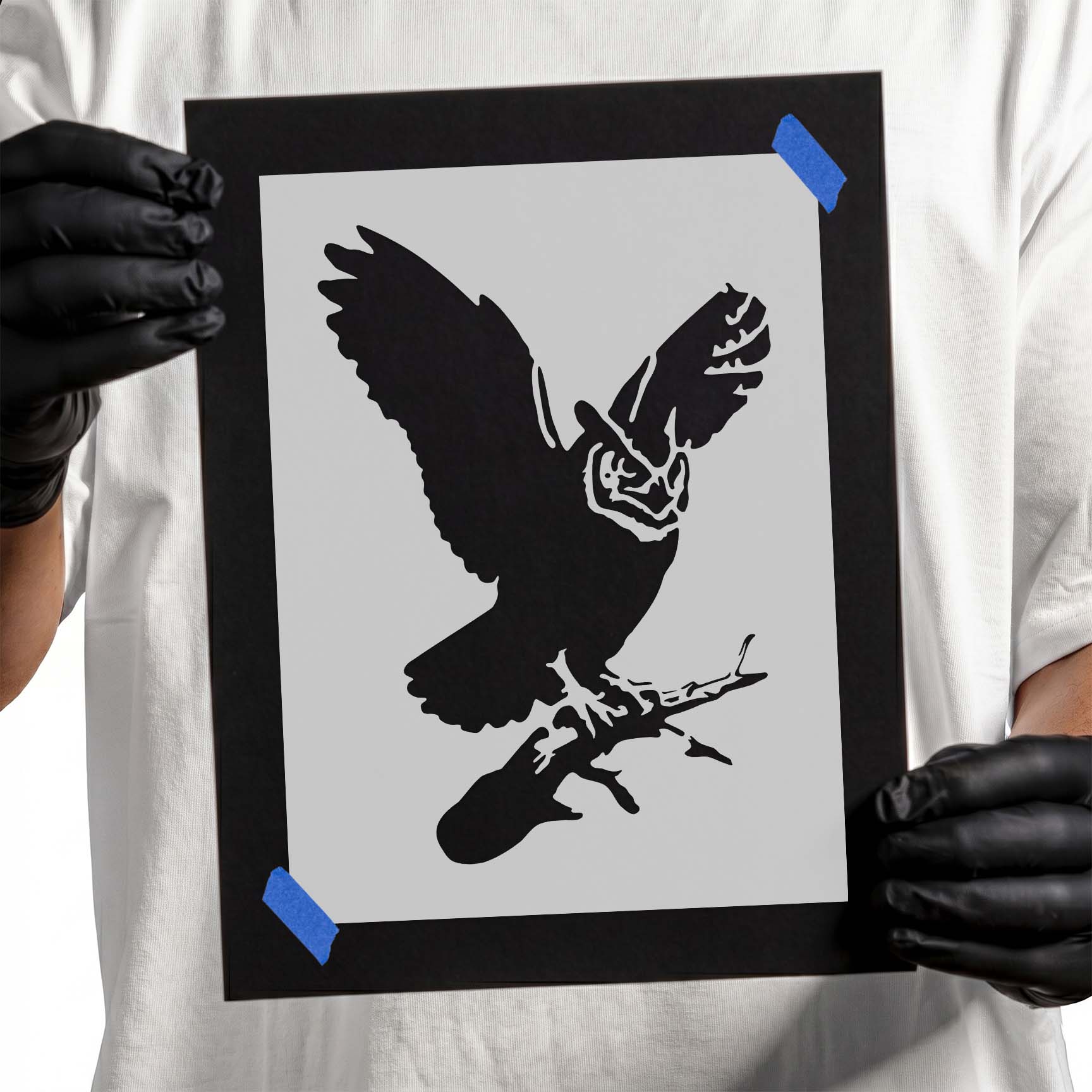 Detailed great horned owl stencil perched on a branch with wings raised wide
