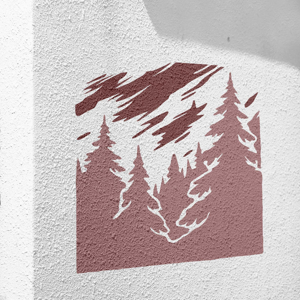 Misty Pine Forest stencil painted burgundy on a textured white wall