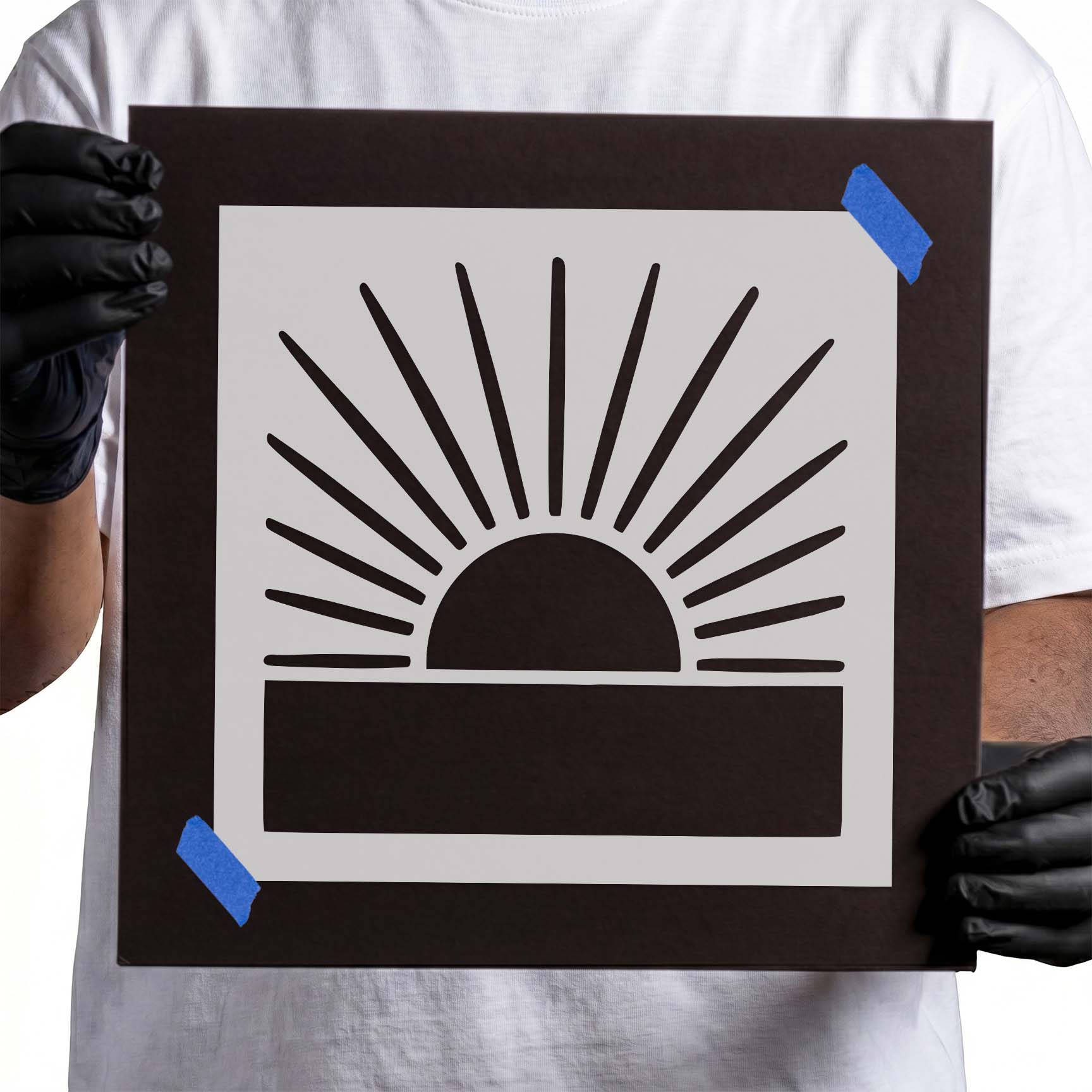 Person holding Radiant Sunrise Horizon Stencil taped to cardboard