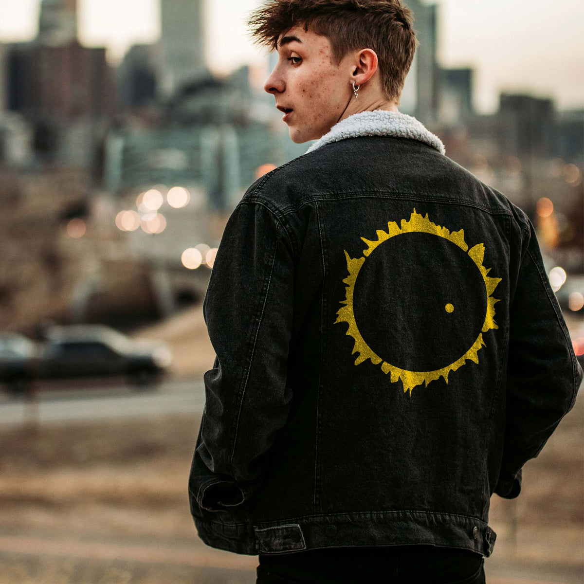 A golden eclipse crowns a black denim jacket with the Solar Eclipse Corona Stencil across the back