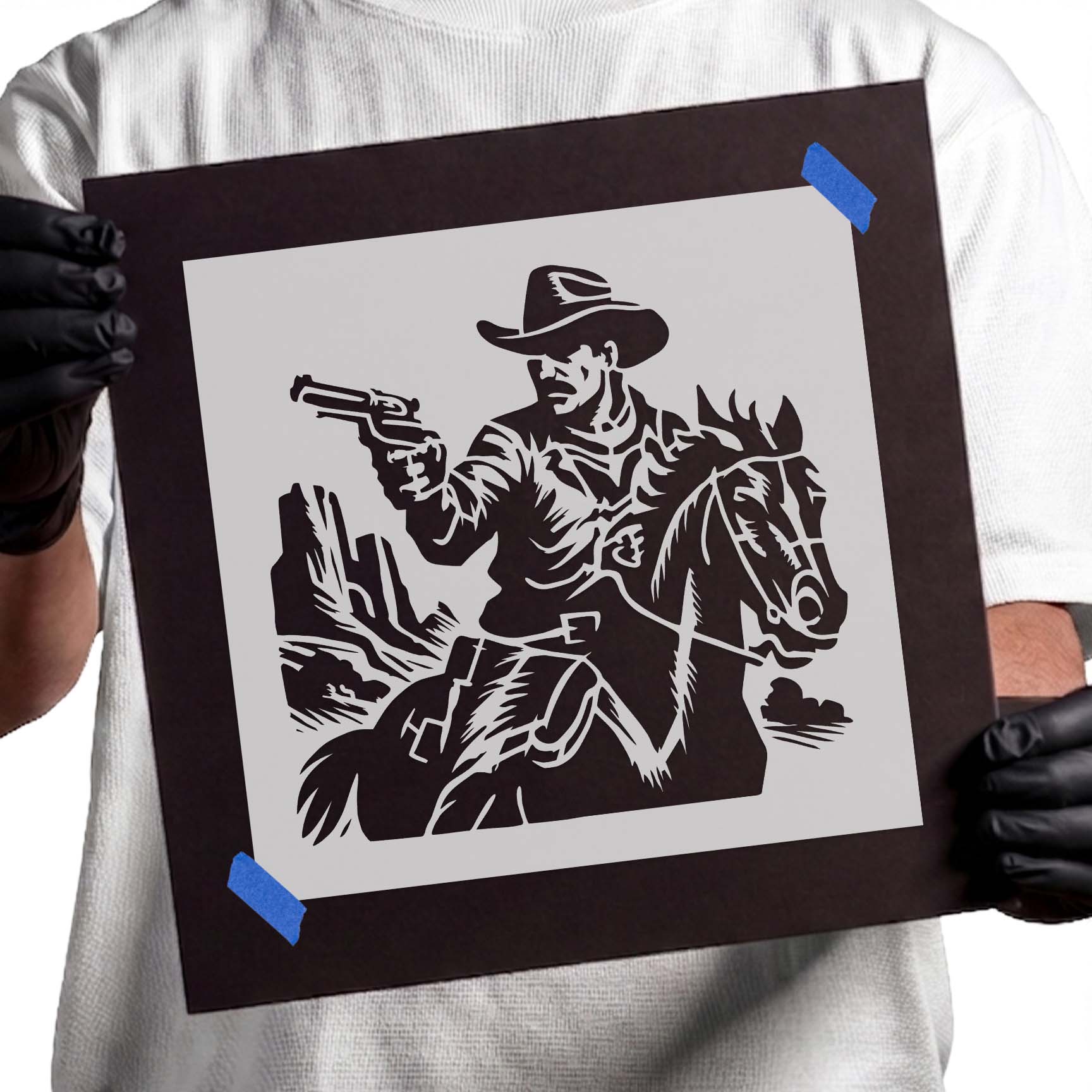 Person holding Wild West Gunslinger Stencil taped to black cardboard