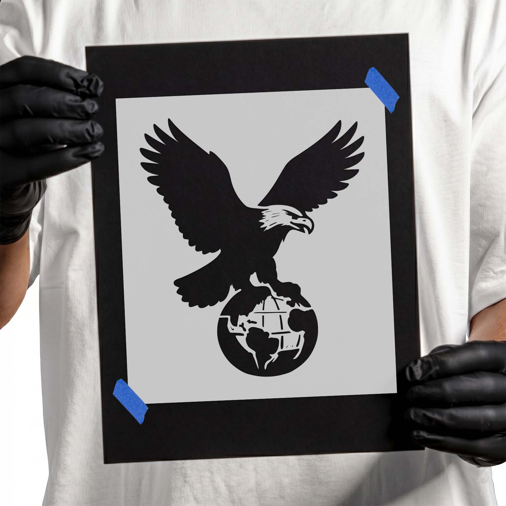 Bald eagle stencil with spread wings perched above a globe