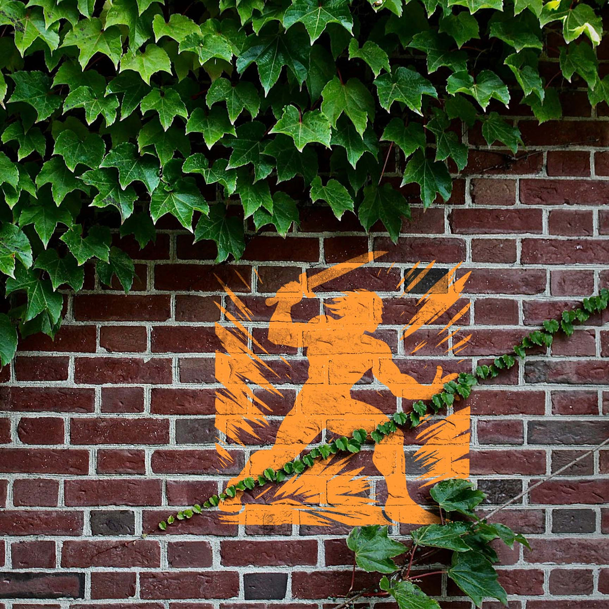 Blade Strike Warrior Stencil painted orange on an ivy-covered brick wall.