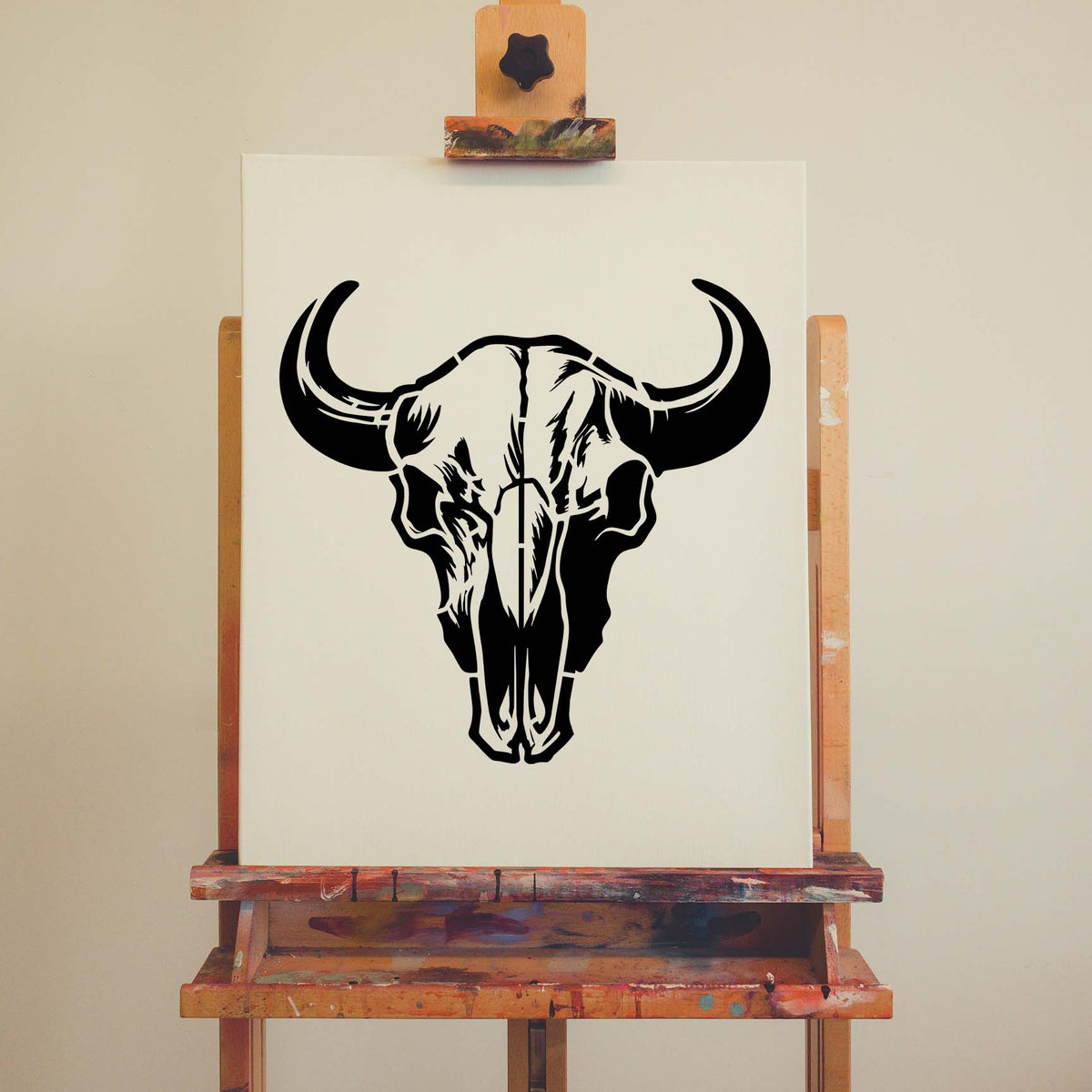 Bold black Buffalo Skull Stencil with sweeping horns displayed on a cream canvas resting on an easel.
