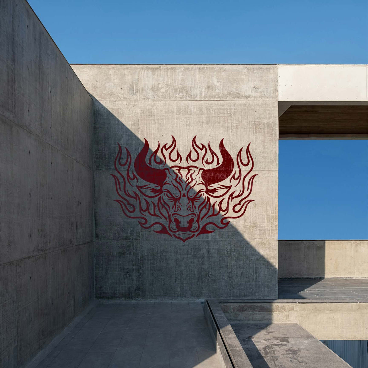 Flaming Bull Head Stencil painted red on a concrete wall with bold horns and surrounding flames.