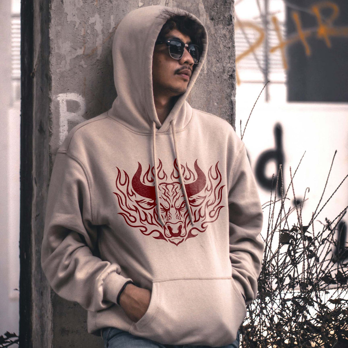 Flaming Bull Head Stencil printed red on a beige hoodie with a fierce horned bull and flame design.