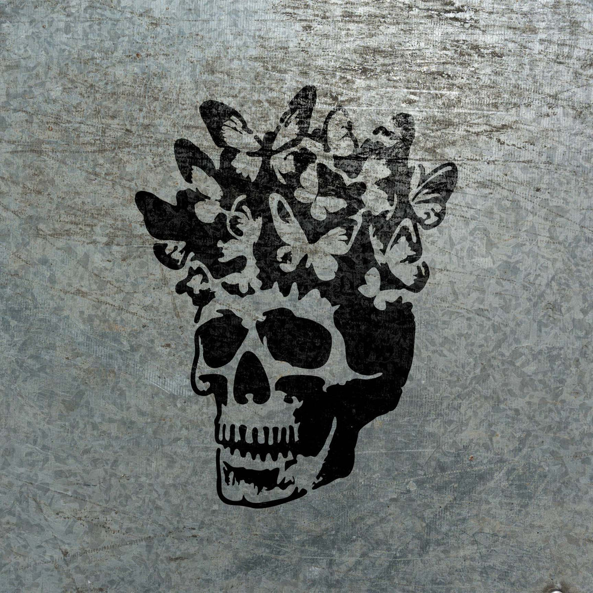 Butterfly Bloom Skull Stencil pairs a bold skull with a lively crown of butterflies on metal