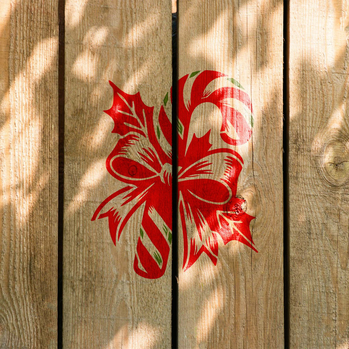 Candy Cane with Festive Bow Stencil painted in festive red and green across rustic wood