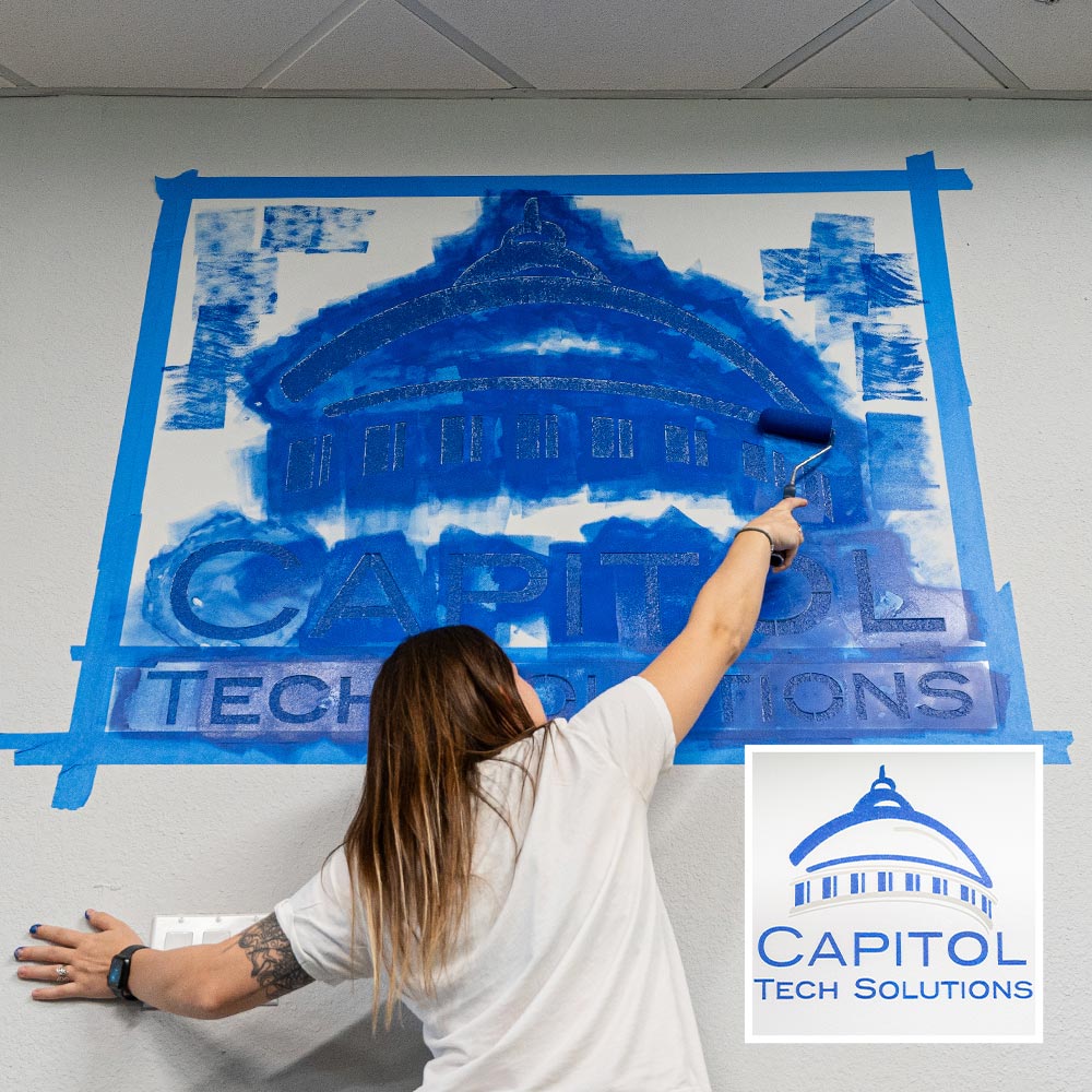 capitol tech solutions large stencil being painted on wall