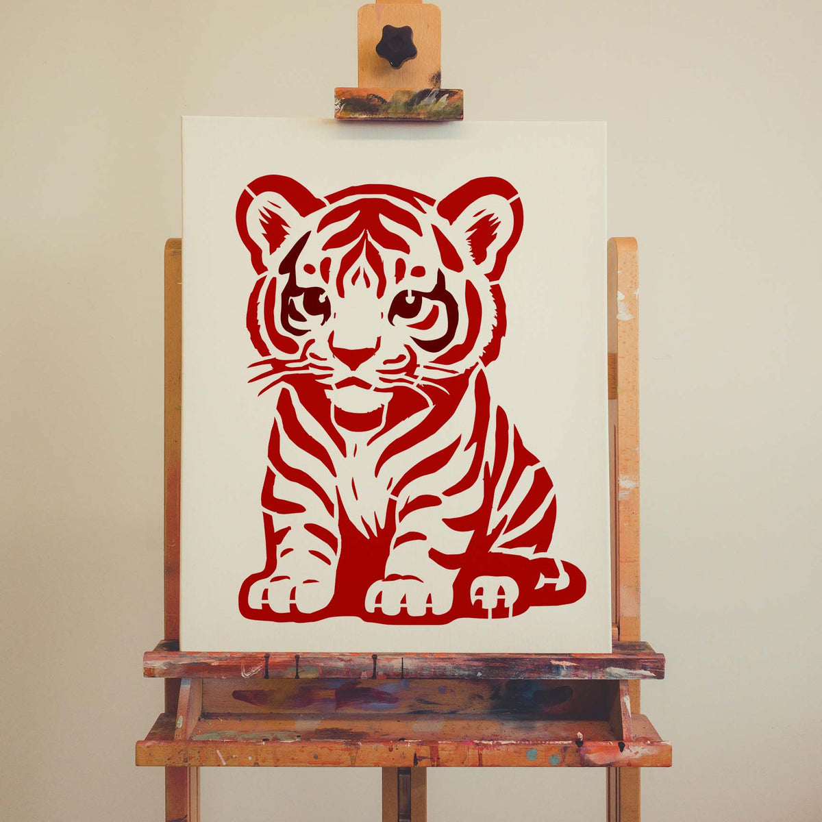 Cartoon Tiger Cub stencil painted red on canvas displayed on an easel