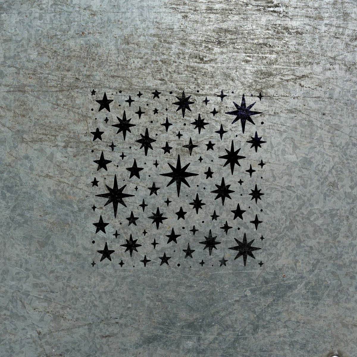 Celestial Star Scatter Stencil painted in black on distressed metal