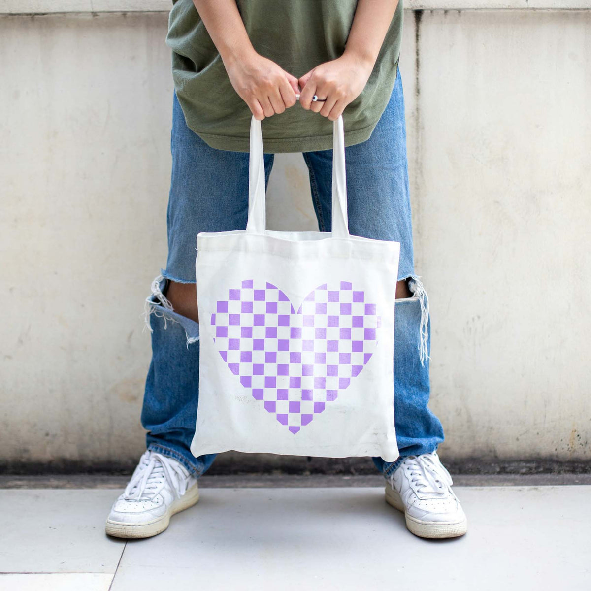 Pastel purple Checkerboard Heart Stencil stands out on a white tote bag held outdoors.