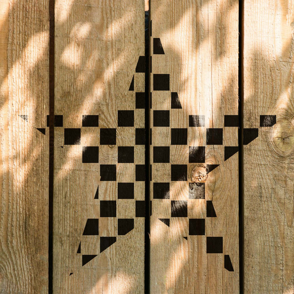 Rustic wood planks display the Checkerboard Star Stencil with a crisp black checkered design